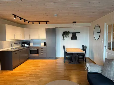 a kitchen and living room with a table and a couch at Apartment with a view at Bavallen Tråstølen Voss in Vossevangen