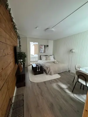 a bedroom with a bed and a table and a television at Bo i Bergens eldste smau på Nøstet - sentralt og rolig in Bergen