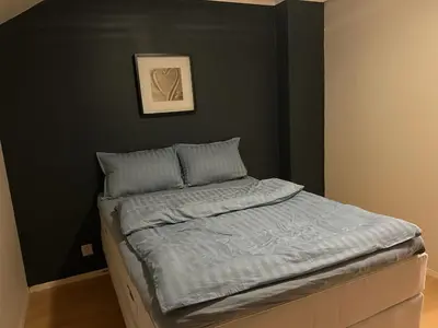 a bed in a bedroom with a picture on the wall at Spacious 3 Bedroom Townhouse in Bergen