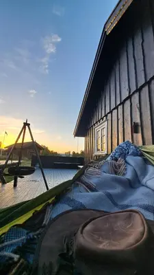 a bed sitting outside of a wooden building at Cozy Cottage in Rauland Vierli in Torvetjørn