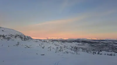 a snow covered hill with trees and mountains in the distance at Cozy Cottage in Rauland Vierli in Torvetjørn