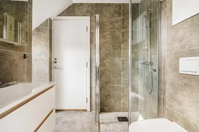 a bathroom with a glass shower with a toilet at DINBNB Apartments l 100m to Bryggen l Pet Friendly l Sleeps 4 l Smart-TV in Bergen