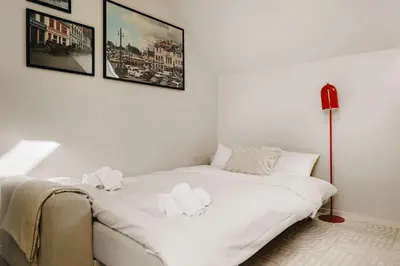 a white bed in a room with a red lamp at DINBNB Apartments l 100m to Bryggen l Pet Friendly l Sleeps 4 l Smart-TV in Bergen