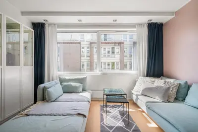 a living room with a couch and a window at Bergen Beds Apartment I Right Behind Bryggen! in Bergen