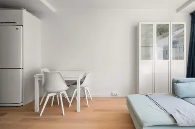 a kitchen with a table and chairs and a refrigerator at Bergen Beds Apartment I Right Behind Bryggen! in Bergen