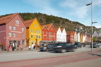 a city with cars driving down a street with buildings at Bergen Beds Apartment I Right Behind Bryggen! in Bergen