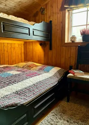 a bedroom with a bed in a wooden cabin at Family-Friendly Mountain Cabin At Haglebu in Haglebu