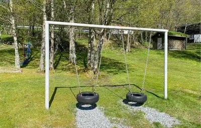 a swing with two tires on it in a yard at 2 Bedroom Lovely Home In Ørsta in Ørsta