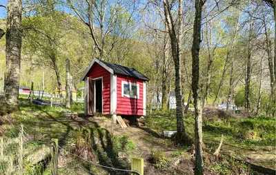 a small red house in the middle of a forest at 2 Bedroom Lovely Home In Ørsta in Ørsta