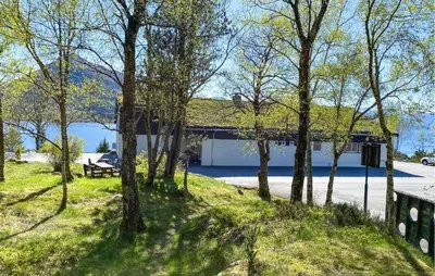 a park with a building with a bench and trees at Awesome Home In Ørsta in Ørsta