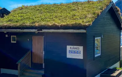 a building with a grass roof with a sign on it at Awesome Home In Ørsta in Ørsta