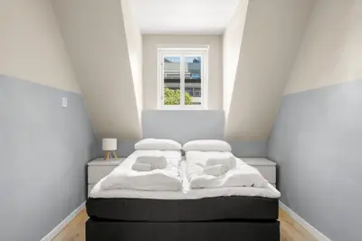 a bedroom with a bed with white sheets and a window at Historic Bergen Home I Free Parking in Bergen