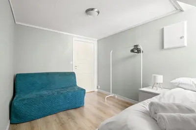 a bedroom with a blue chair next to a bed at Historic Bergen Home I Free Parking in Bergen