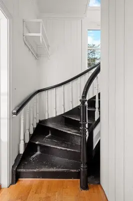 a black spiral staircase in a white room with a window at Historic Bergen Home I Free Parking in Bergen