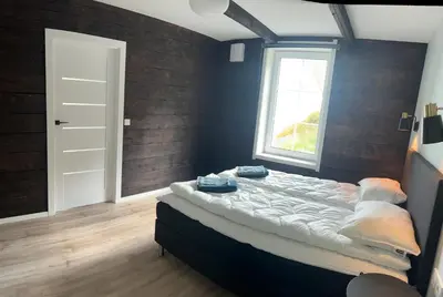 a large bed in a room with a window at Husslåttene apartments 2 in Skei