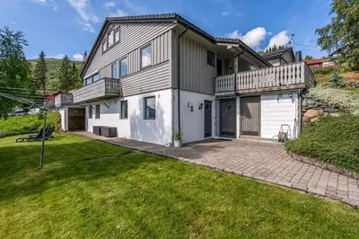 an exterior view of a house with a large yard at Leilighet i Røldal in Håra
