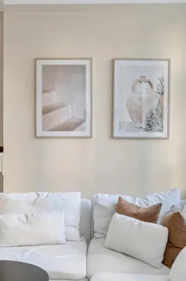 a white couch in a living room with two pictures on the wall at Central Charm in Bergen