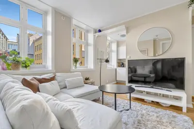 a living room with a white couch and a large tv at Central Charm in Bergen