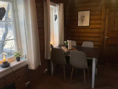 a dining room with a table and chairs and a window at Log Cabin With Mountain View in Beitostøl