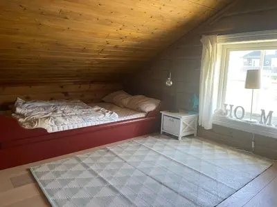 a bedroom with a bed in a room with a window at Log Cabin With Mountain View in Beitostøl