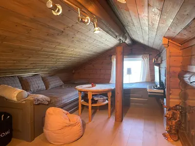 a room with a bed and a table in a cabin at Log Cabin With Mountain View in Beitostøl