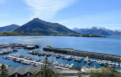 a group of boats docked in a marina with mountains at Amazing Home In Ørsta With Wifi in Ørsta