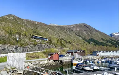 a bunch of boats docked in a harbor with a mountain at Amazing Home In Ørsta With Wifi in Ørsta
