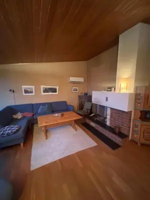 a living room with a blue couch and a table at 4 bedroom room House in Beautiful Strandebarm in Kvam