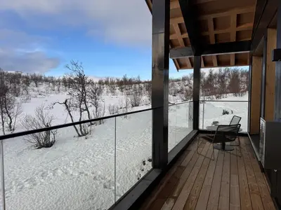 a balcony with a view of a snow covered field at Kikut Alpin Lodge 1301 in Hol
