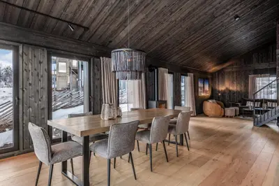 a dining room with a wooden table and chairs at Kikut Alpin Lodge 1301 in Hol