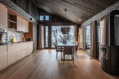 a kitchen with a table and chairs in a room at Kikut Alpin Lodge 1301 in Hol