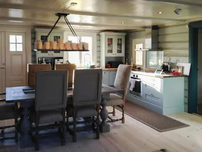 a kitchen with a table and chairs in a kitchen at Charming Log Cabin With Modern Luxury in Dagali
