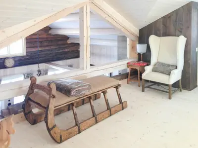a living room with a bench and a chair at Charming Log Cabin With Modern Luxury in Dagali