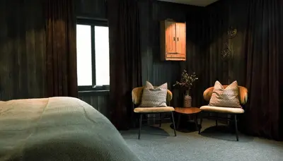 a bedroom with two chairs with pillows and a bed at Sov Lodge in Vågåmo