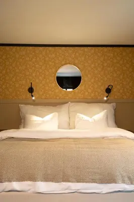 a bedroom with a large bed with a mirror above it at Sov Lodge in Vågåmo