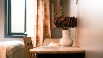 a vase with flowers on a table in a room at Sov Lodge in Vågåmo