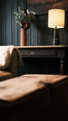 a table with a lamp and a vase of flowers on it at Sov Lodge in Vågåmo