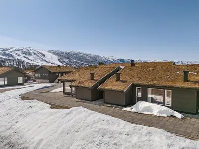 a group of houses in the snow with mountains at Beautiful City Cottage at Geilotunet in Hol