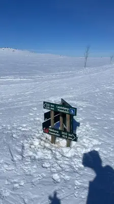 a shadow of a person in the snow with street signs at Mountain villa with amazing view of Hardangervidda! in Nørdstebø
