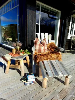 a wooden bench and a table on a porch at Mountain villa with amazing view of Hardangervidda! in Nørdstebø