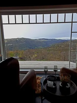 a living room with a large window with a view at Mountain villa with amazing view of Hardangervidda! in Nørdstebø