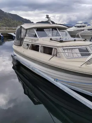 a white boat is docked in the water at Flamingo in Vikedal