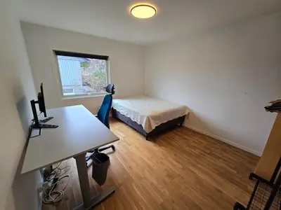 a small room with a bed and a desk in it at 6 Bedroom House in Ålesund