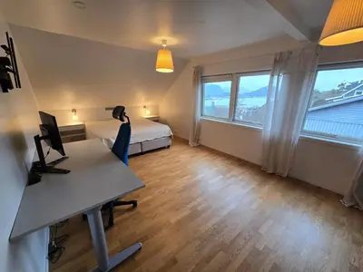 a room with a bed and a desk with a computer at 6 Bedroom House in Ålesund