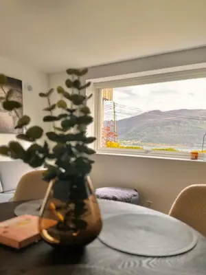 a vase sitting on a table with a plant at Cozy basement apartment in Ålesund