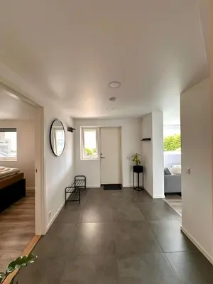 a hallway of a house with a door and a mirror at Cozy basement apartment in Ålesund
