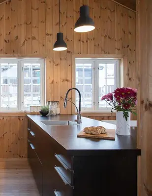 a kitchen with a counter with a sink and two windows at Modern Mountain Cabin With Views At Filefjell in Tyinkrysset