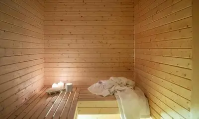 a wooden sauna with a tub and towels in it at Modern Mountain Cabin With Views At Filefjell in Tyinkrysset