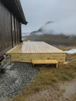 a wooden deck on the side of a building at Modern Mountain Cabin With Views At Filefjell in Tyinkrysset