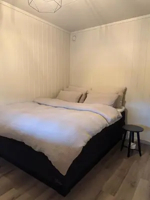 a large bed in a room with a table at Sentral leilighet i Åsane in Sørebø